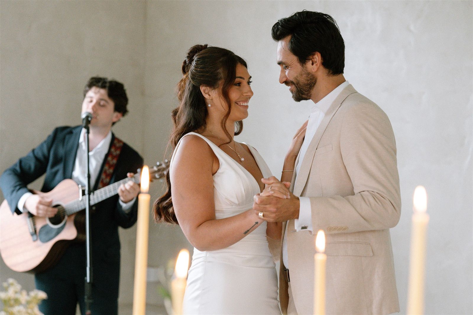 A couple dancing while Harry Morris plays acoustic guitar behind them